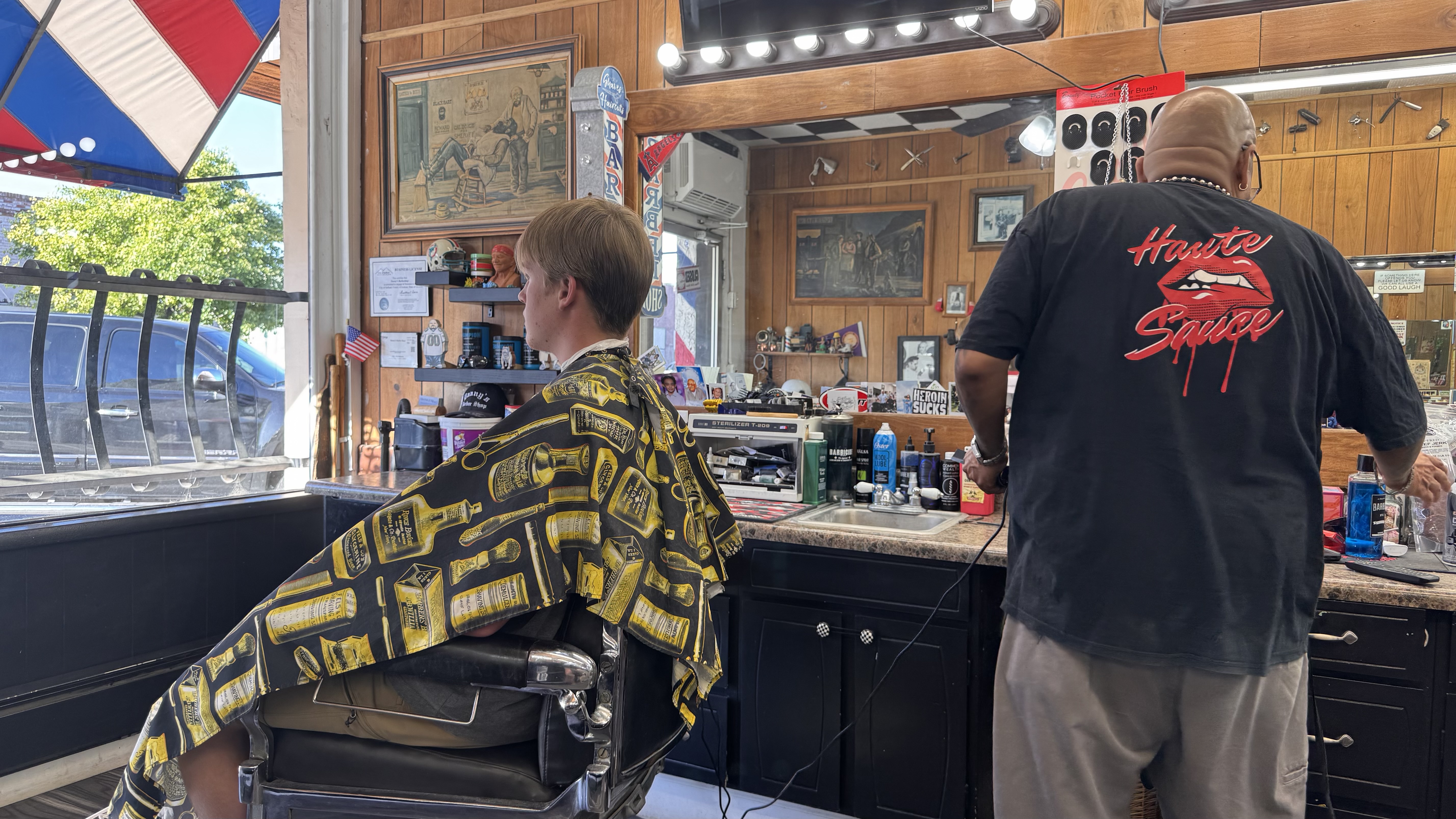 Inside Danny's Barber Shop with barber chair, mirror lights, and wood-paneled walls